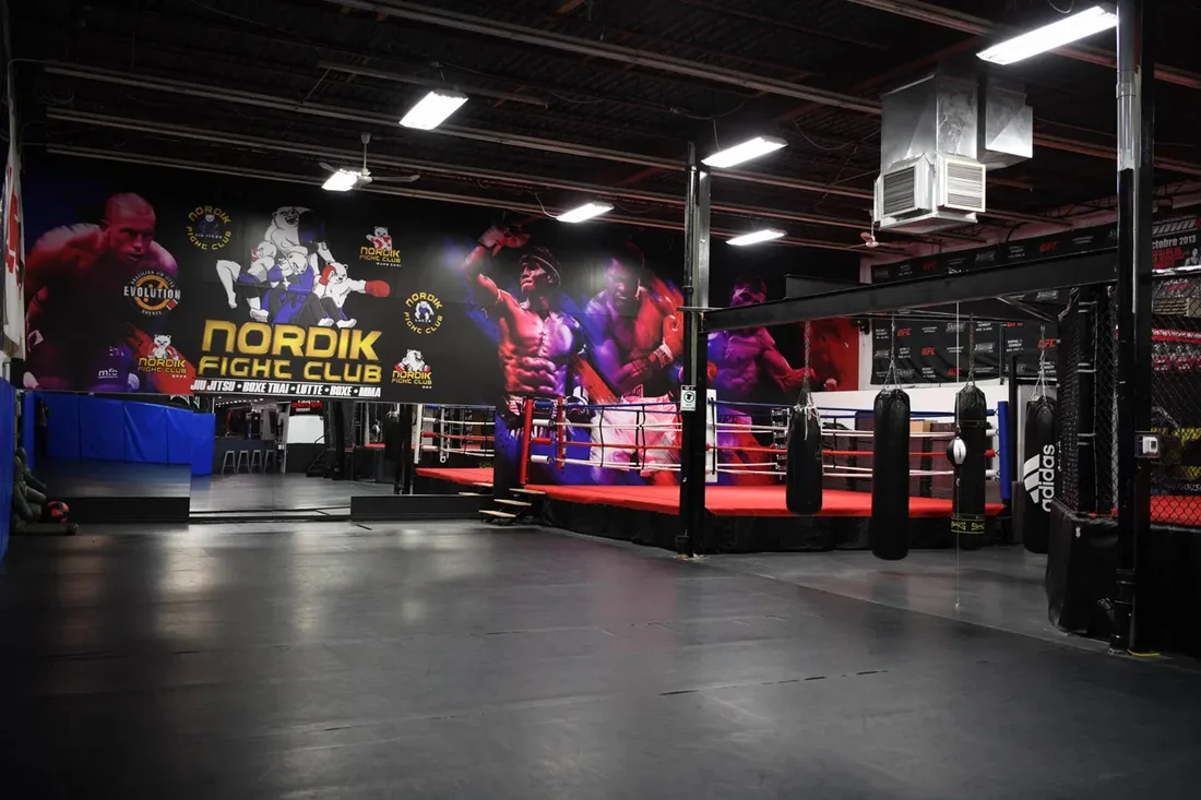 Intérieur du Nordik Fight Club à Québec — logo Nordik, ring et sacs de frappe